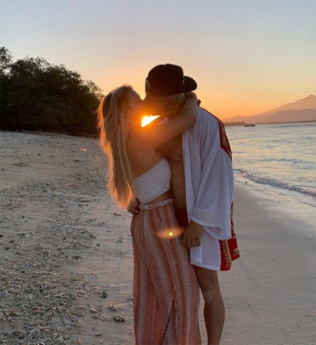 Vitaly and Kinsey kissing on the beach before the sun sets.